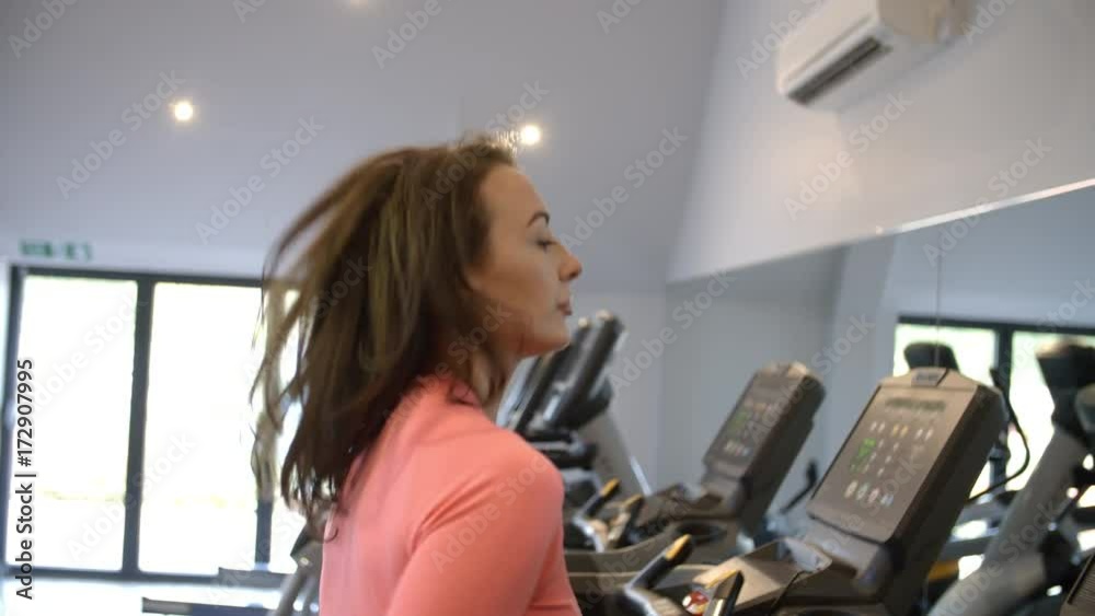 Woman on running machine at a gym, close up Woman on running machine at a gym, close up