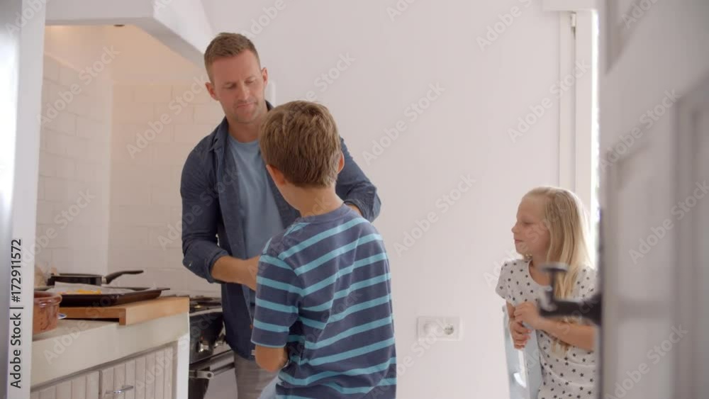 Father And Children Putting Fries Into The Oven Father And Children Putting Fries Into The Oven