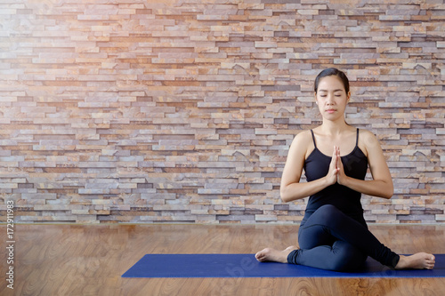 Portrait of gorgeous young woman practicing yoga indoor. Calmness and relax, female happiness.