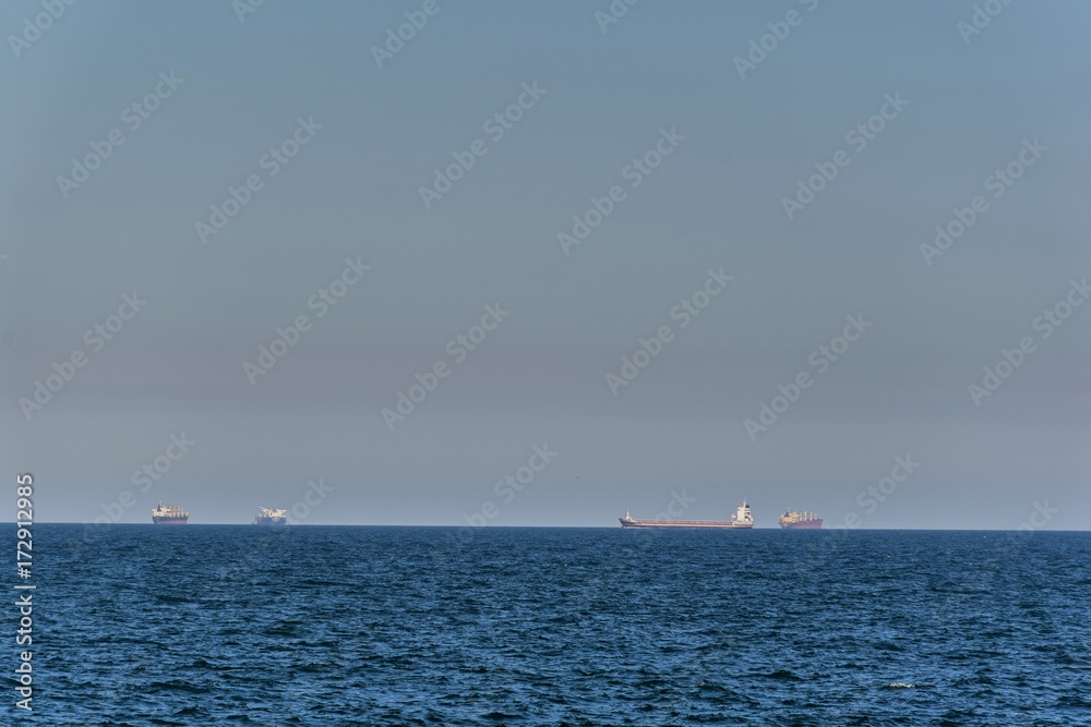  Large cargo ships waiting to be loaded or unloaded in offshore. Large containers ship or tanker on horizon in Black Sea.