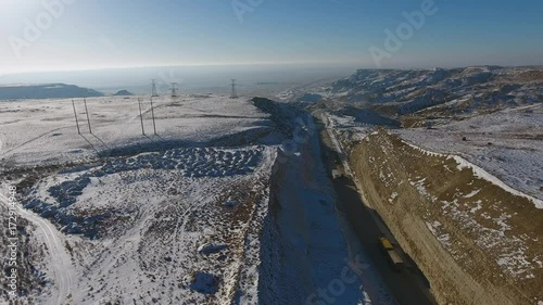 Aerial view of three suvs moving along the highway in the desert in winter. Western Kazakhstan, Mangyshlak Peninsula.