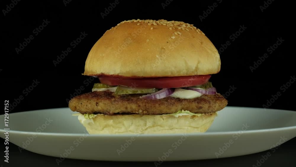 Fresh appetizing burger with chiken rotating on black background. UHD 4k. Fresh appetizing burger with chiken rotating on black background. UHD 4k.