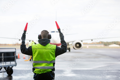 Ground Crew Signaling To Airplane photo