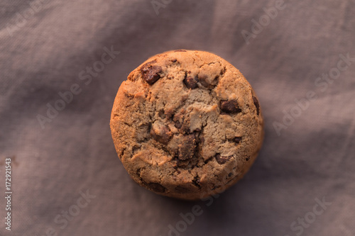 Stack of chocolate chips cookies on brown background
