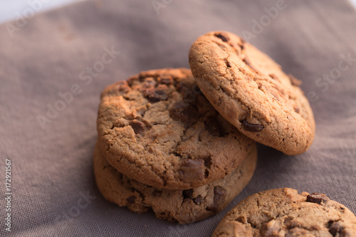 Stack of chocolate chips cookies on brown background