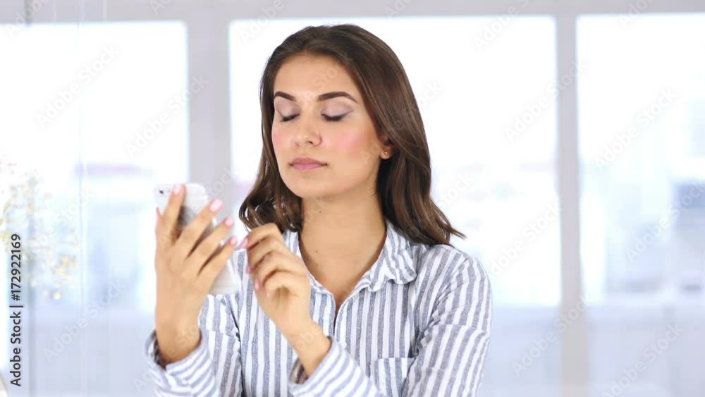 Woman at Work Browsing Smartphone in Office Woman at Work Browsing Smartphone in Office