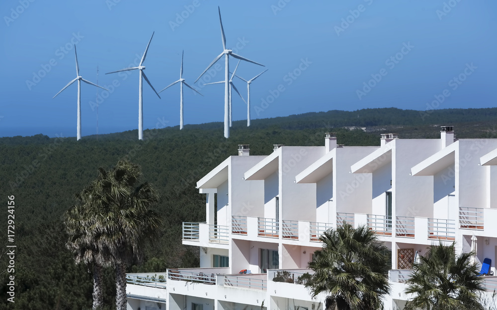 Landscape of white modern buildings and big electric windmills background
