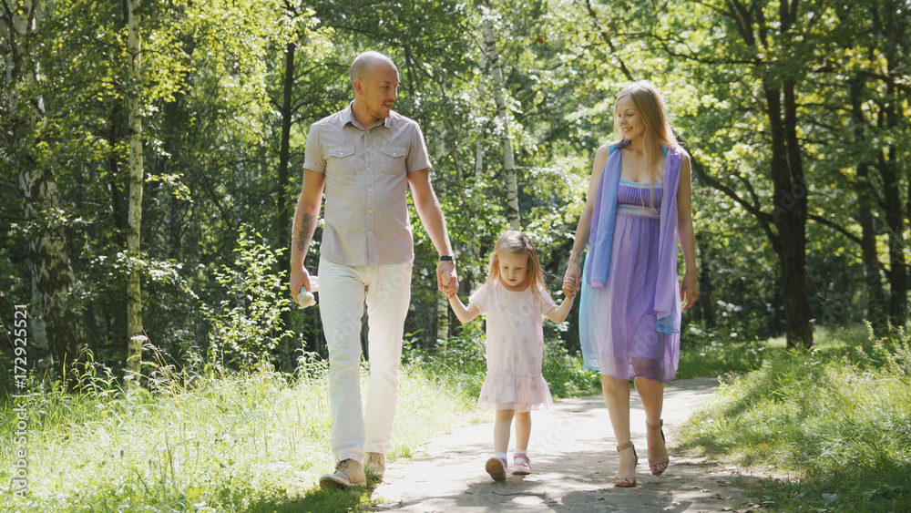 Happy family walking in the park at sunny day Happy family walking in the park at sunny day