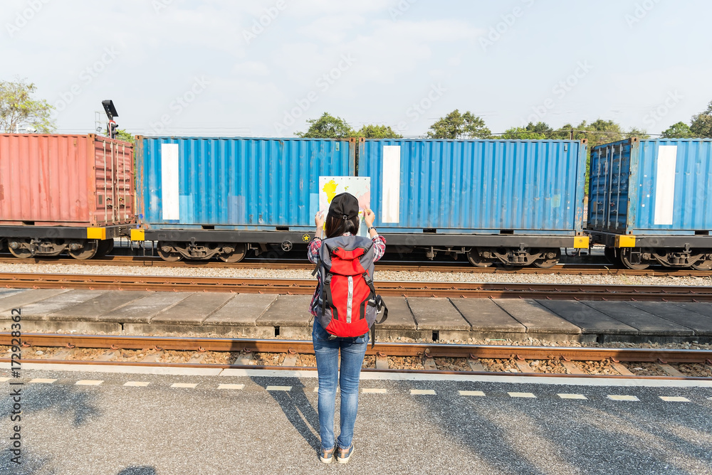 Traveler women walking alone Carrying luggage and waits train on railway station.