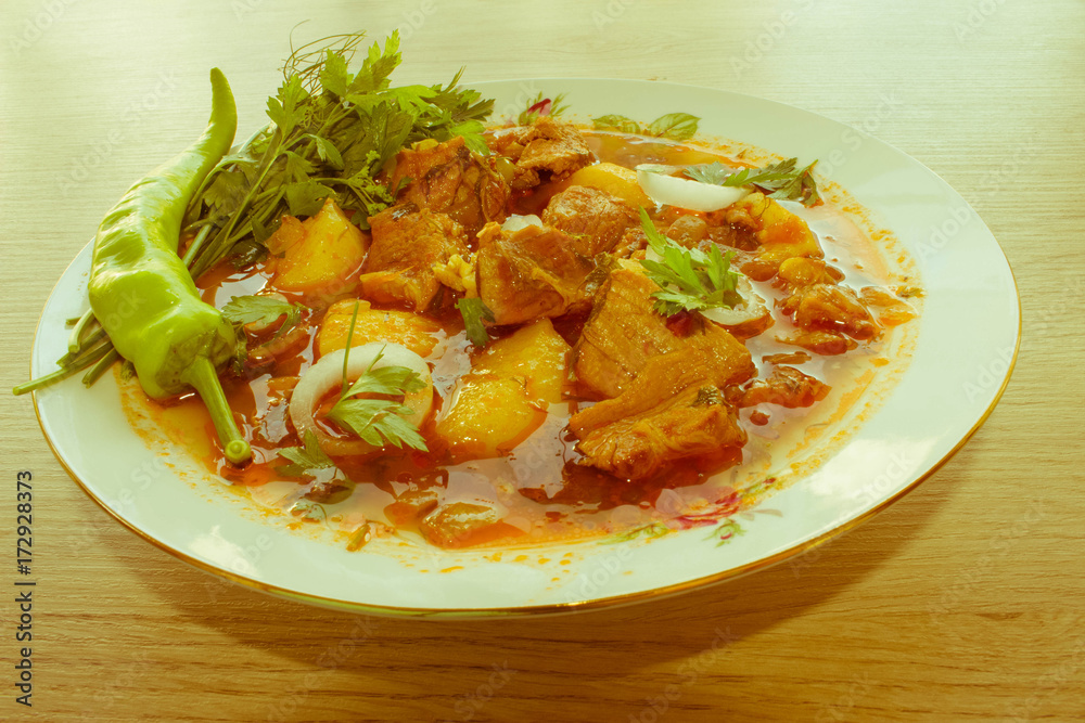 Tasty winter stew with meat and vegetables in bowl with ingredie