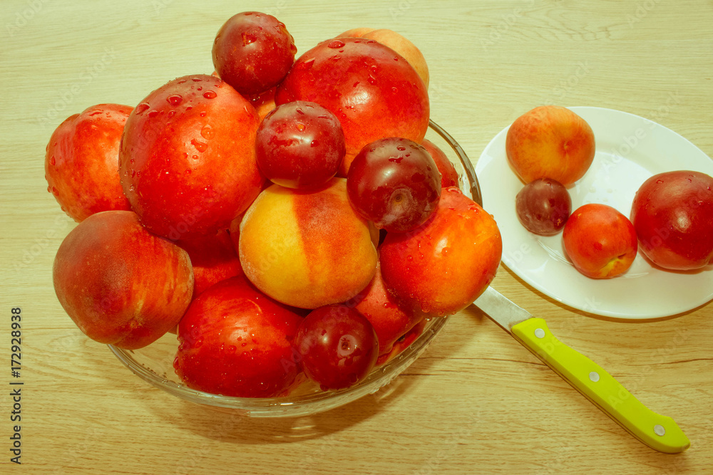 Nectarine, peaches and plums with water drops on wood table. fru