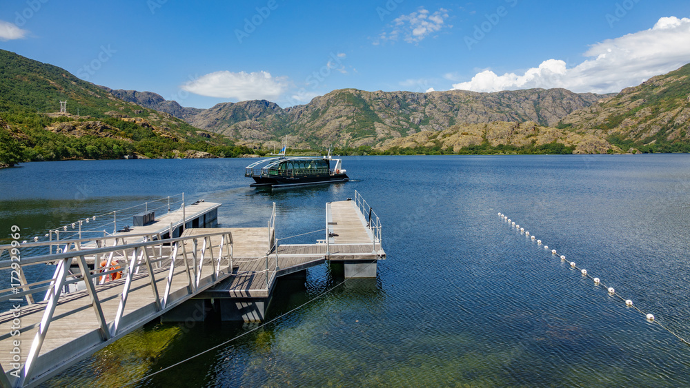 Naklejka premium Solar boat leaving pier in Sanabrias Lake