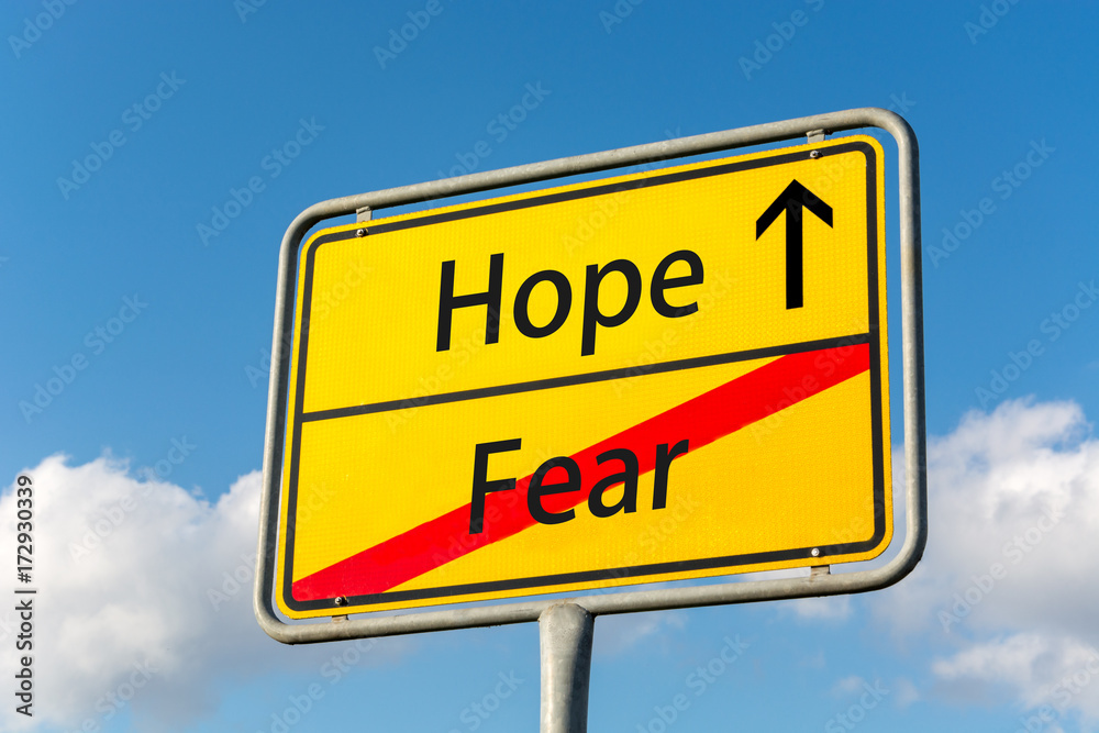 Yellow street sign with Hope ahead leaving Fear behind Yellow street sign with Hope ahead leaving Fear behind