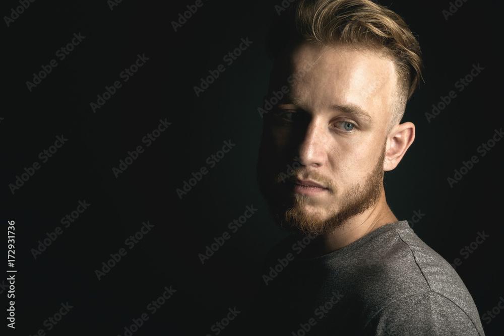 portrait of young man above black background