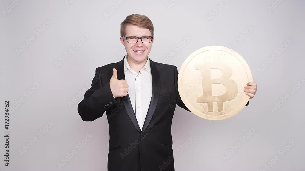 A man holds a big coin bitcoin A man holds a big coin bitcoin