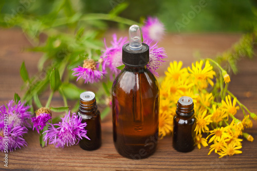 essential oil on table in beautiful bottle with flowers