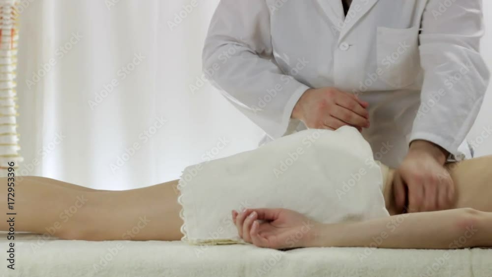 Professional masseur doing back massage young girls in a massage parlor