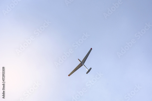 Glider flying on a blue sky background