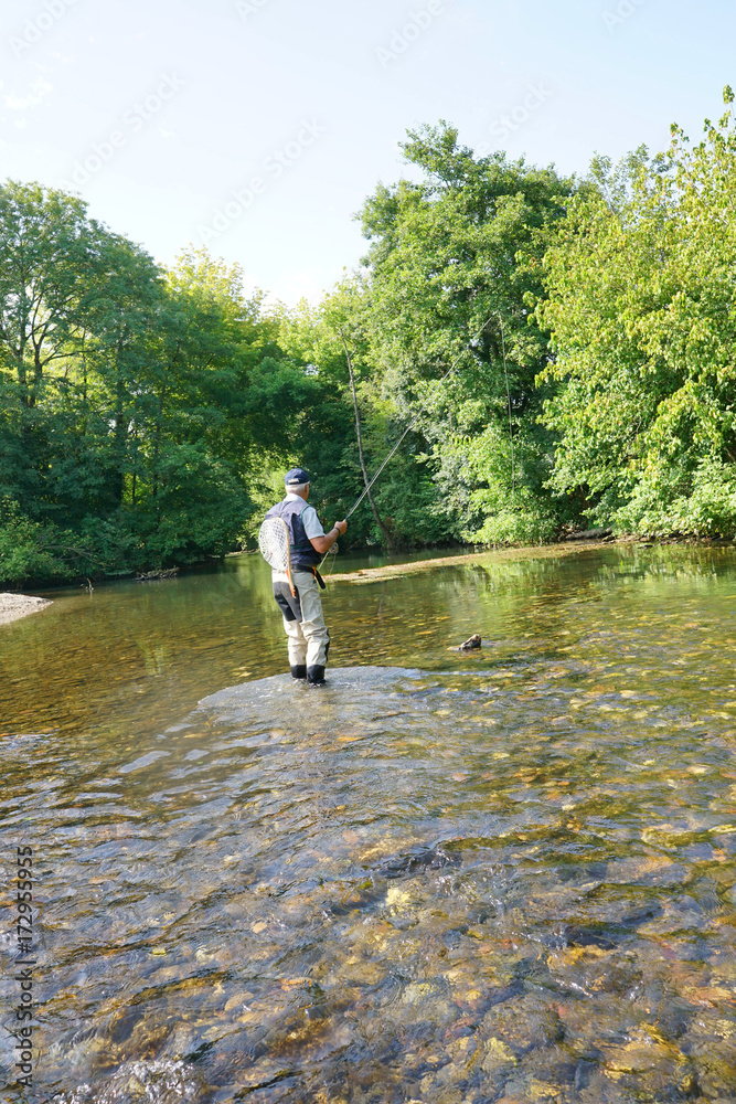 Fly fisherman fishing in French river Fly fisherman fishing in French river