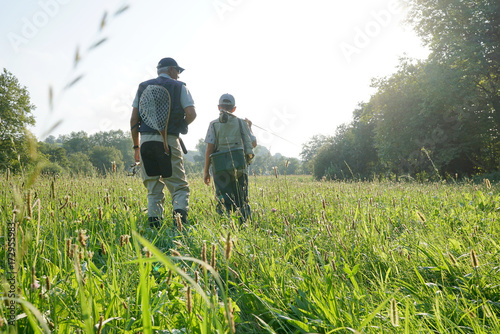  Daddy and son walking in field, fishing day