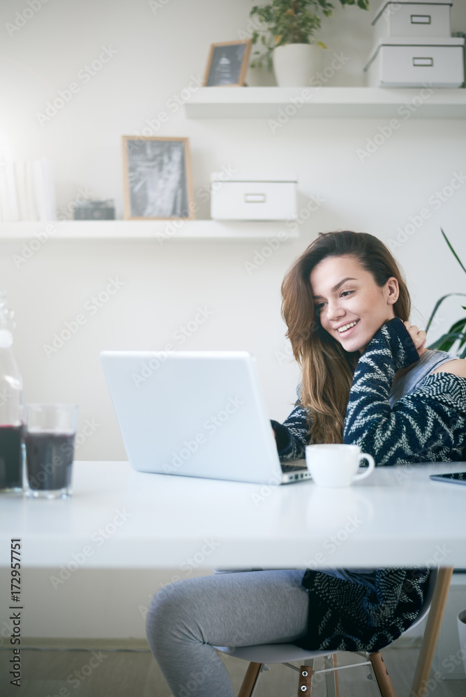 Caucasian girl using laptop and drinking coffee while sitting in study room Caucasian girl using laptop and drinking coffee while sitting in study room