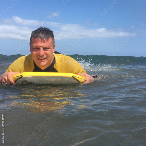 Man riding on bodyboard in ocean © Camillo