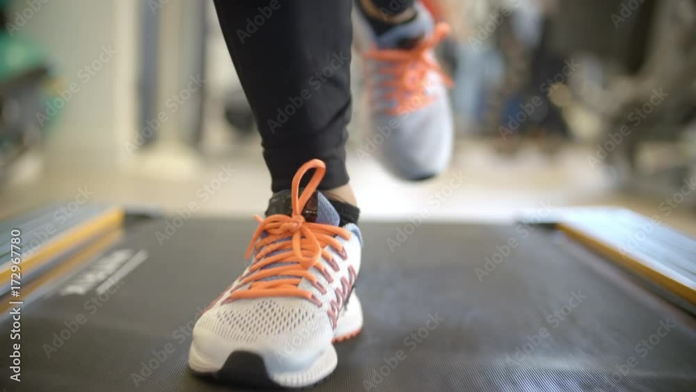 Close up of persons feet on a running machine, front view
