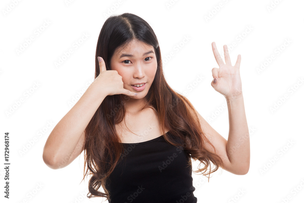 Young Asian woman show with phone gesture and OK sign. Young Asian woman show with phone gesture and OK sign.