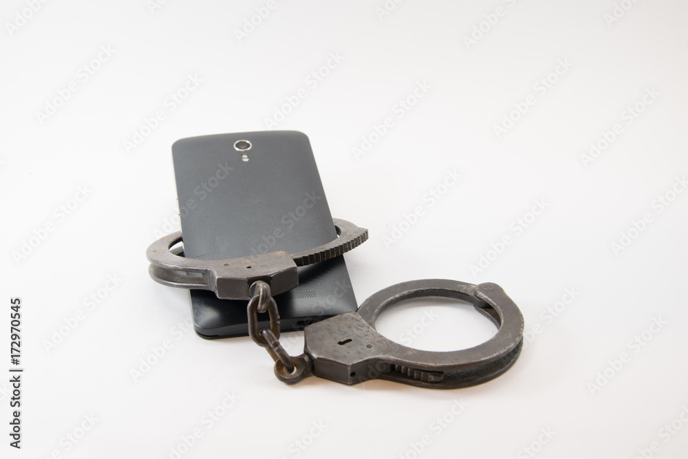 Obraz premium locked phone. phone locked with handcuffs on white background