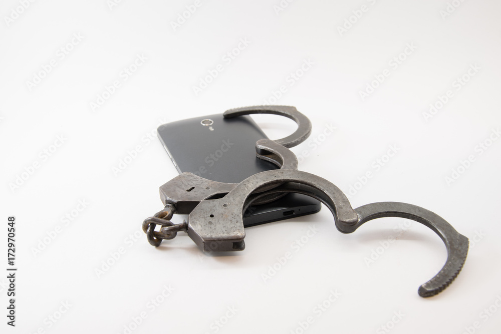 unlocked phone. phone with unlocked handcuffs on white background unlocked phone. phone with unlocked handcuffs on white background