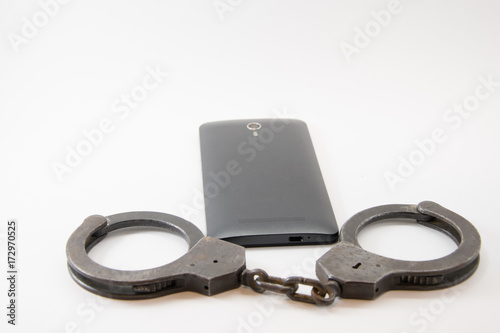 locked phone. phone locked with handcuffs on white background