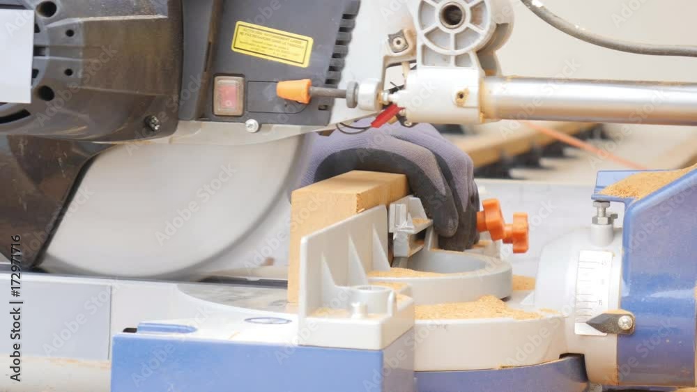 close up detail of manual worker hands using a power tool circular saw close up detail of manual worker hands using a power tool circular saw
