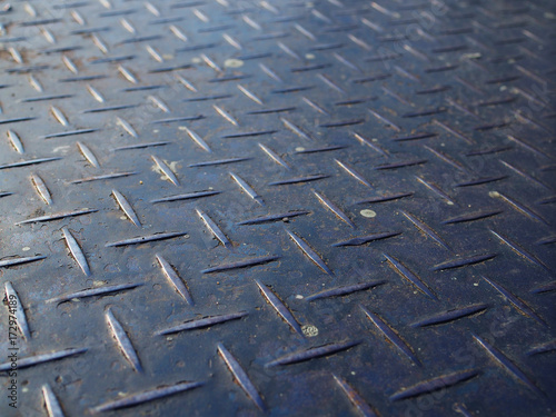 Perspective close up old rusty dirty white painted stained scratched blue iron steel checker plate background, full of dust