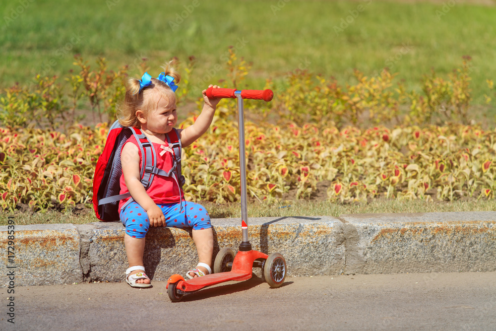 cute little girl tired of scooter ride, ambitious parent concept