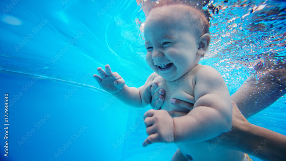 Baby background. Happy infant learn to swim, dive underwater with fun in pool to keep fit. - obrazy, fototapety, plakaty 