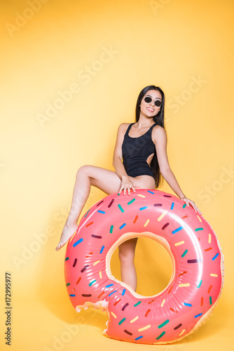 woman in swimsuit with doughnut pool float