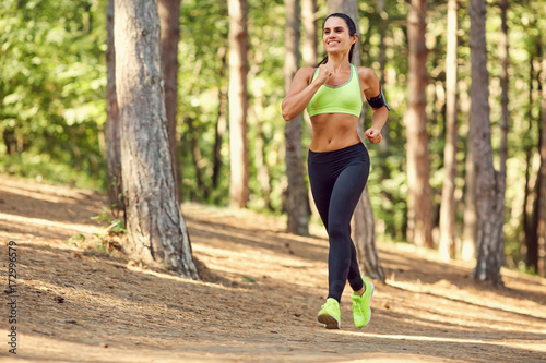 A girl jogging in the woods outdoors. Healthy lifestyle.