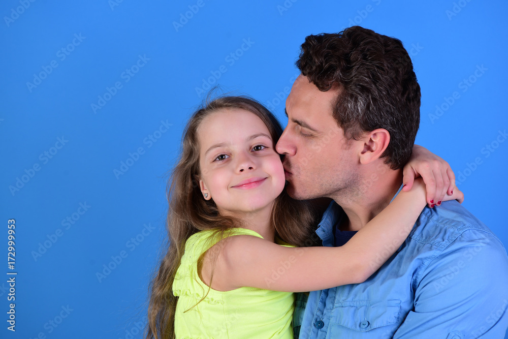 Childhood and family concept. Dad kisses his daughter in cheek. Childhood and family concept. Dad kisses his daughter in cheek.