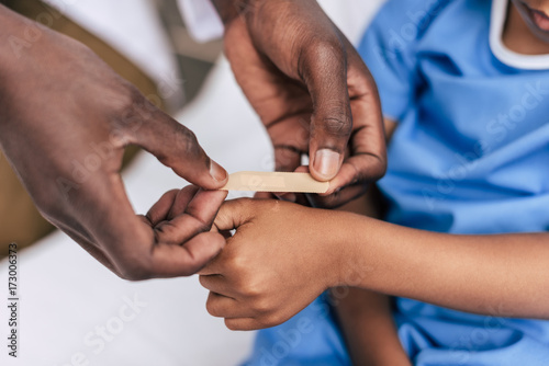 african american doctor putting adhesive plaster