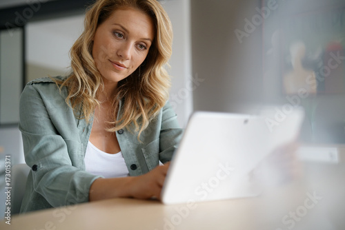 Woman sitting at home websufing on internet with digital tablet
