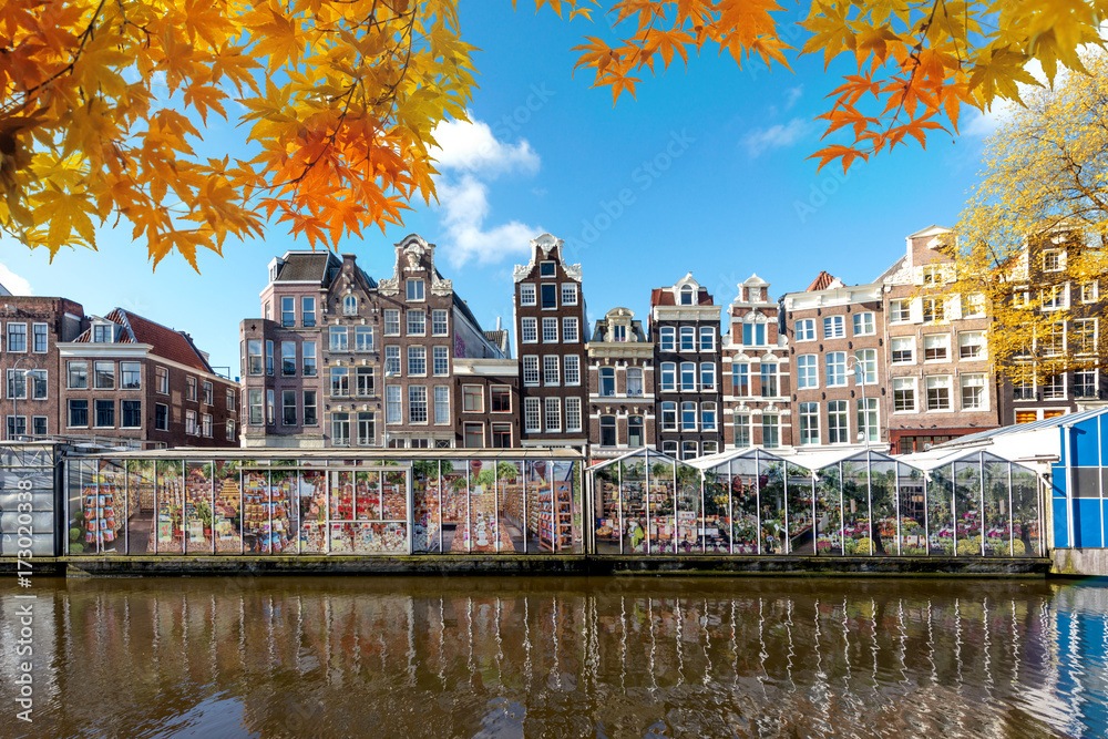 Autumn season at Amsterdam street traditional ancient dutch colorful buildings and flower market on Single canal in Amsterdam, Netherlands.