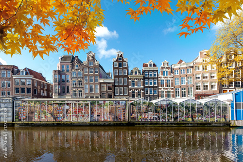 Photography Autumn season at Amsterdam street traditional ancient dutch colorful buildings and flower market on Single canal in Amsterdam, Netherlands
