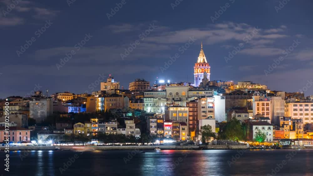 Istanbul cityscape with Galata Tower and floating tourist boats in Bosphorus night timelapse
