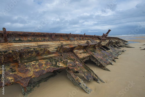 Shipwreck laying on a beach on fraser island Australia half covered in sand. vintage metal bits