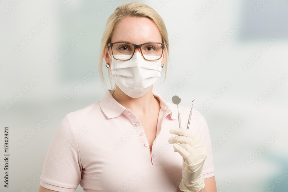 Junge hübsche Zahnarzthelferin mit Instrumenten StockFoto Adobe Stock