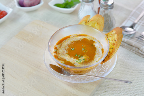 Lobster soup cream and on garlic bread wood cutting board.