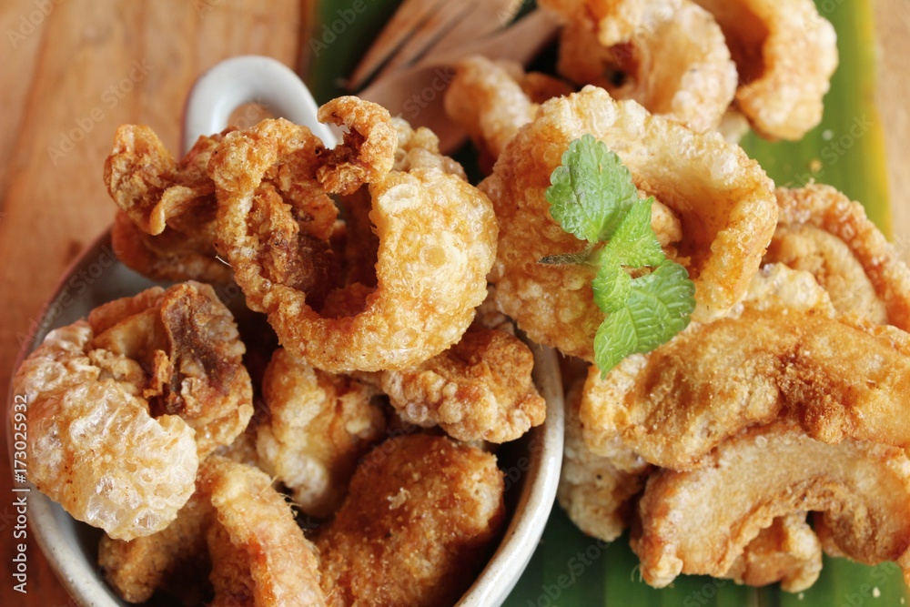 Fried pork skin is delicious on wood background Fried pork skin is delicious on wood background