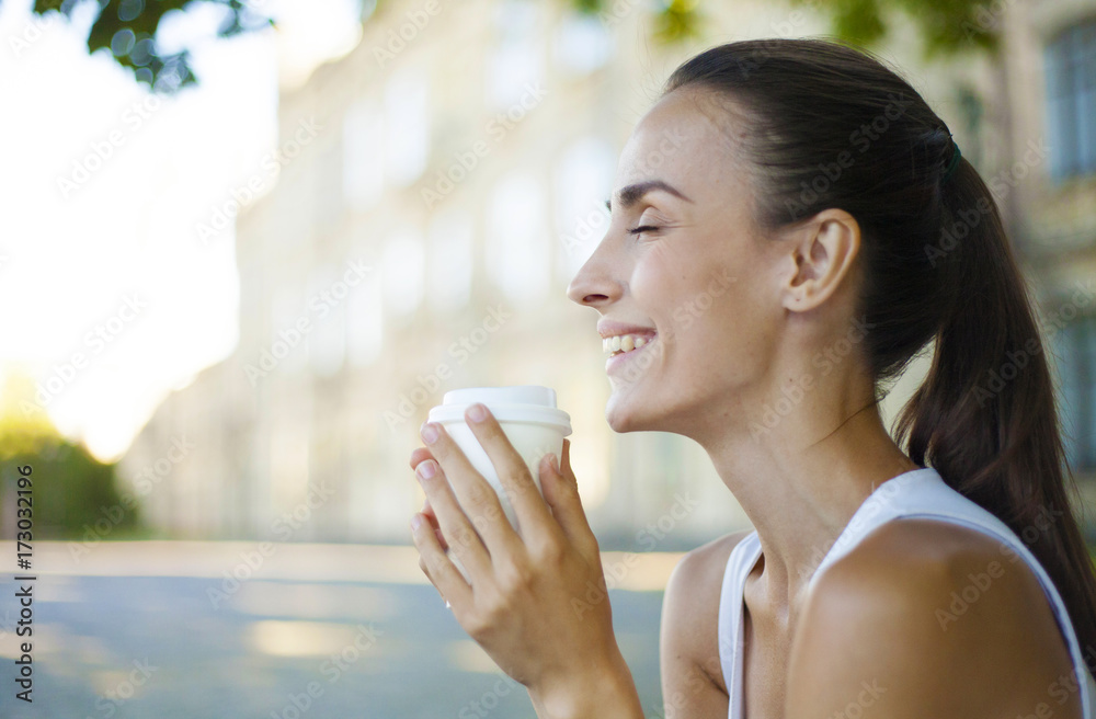 Portrait of a smiling beautiful young woman with coffee in hand.