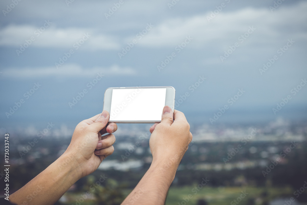 Mock up hand hold smart phone blurred city background