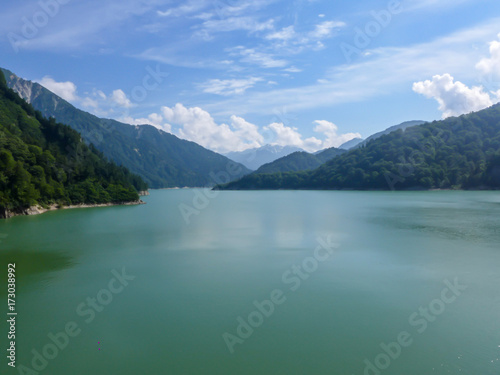 The lake with mountain and blue sky with cloud above the Kurobe dam in Japan